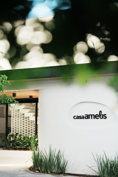 Fachada da Casa Amelis, em Natal/RN, com vegetação e luz natural